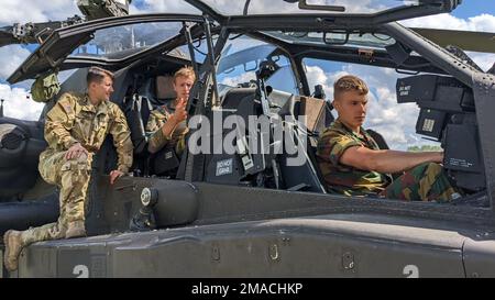 1. LT. Sarah Dolitsky von Bravo Truppe, 7. Geschwader, 17. Kavallerie-Regiment zeigt belgische Soldaten des 103. ISTAR-Bataillons das Cockpit und die Funktionen einer US-Armee Army AH-64 Apache während Combined Resolve XVII in Hohenfels Trainingsgelände, Deutschland, 25. Mai 2022. CBR17 ist eine Rotation der US-Armee Europa und Afrika, die die Mission Essential Training Proficiency einer Einheit in Unified Land Operations in einem entscheidenden Trainingsumfeld zertifiziert und an der etwa 5.000 Soldaten aus den USA, Alliierten und Partnerländern beteiligt sind. Stockfoto