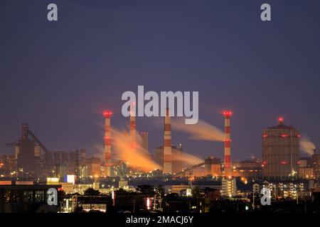 Gasemissionen aus Industrieanlagen in Wohngebieten bei Nacht Stockfoto