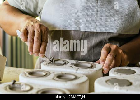 Potter arbeitet in ihrem Kunstatelier. Keramikherstellungsprozess. Meister Potter arbeitet in ihrem Atelier. Stockfoto