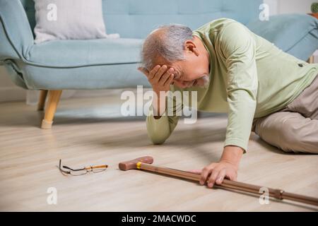 Kopfschmerz älterer Senioren auf dem Boden nach dem Sturz Stockfoto