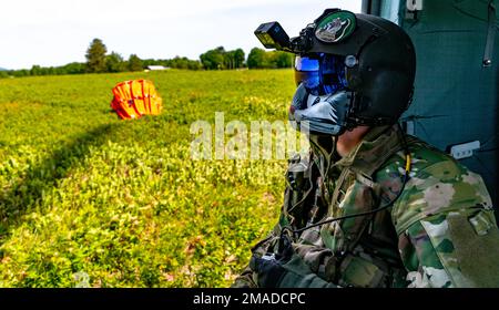 USA Army Sgt. Ryann Gummoe, Crewchef der Charlie Company, 3. Bataillon, 142. Luftregime, Connecticut Army National Guard, sitzt in einem UH-60m Blackhawk Hubschrauber am Westover Air Reserve Base, Chicopee, Massachusetts, 25. Mai 2022. An der Seite von Gummoe befindet sich ein Helikoptereimer, auch bekannt als Bambi-Eimer, der bei der Luftbrandbekämpfung zum Transport von Wasser zur Brandbekämpfung verwendet wird. Stockfoto