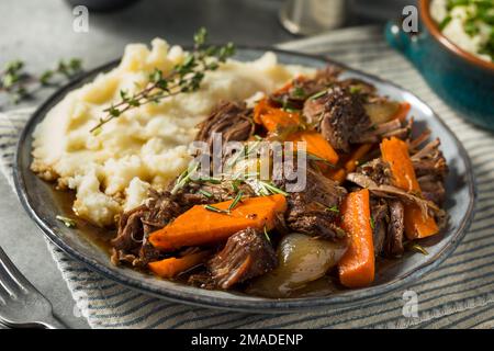 Hausgemachter Rindfleischbraten mit Karotten und Kartoffelpüree Stockfoto