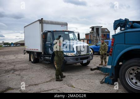 Mitglieder des 442d Logistics Readines Staffelflugs trainierten am 25. Mai 2022 in Royal Air Force Mildenhall, England, ein gestrandetes Auto auf einen Tieflader zu heben und einen simulierten Tankwagen abzuschleppen. Die Schulung wurde von Herrn Nicholas Turpin, dem 100 LRS Vehicle Operations Training Manager, durchgeführt. Stockfoto