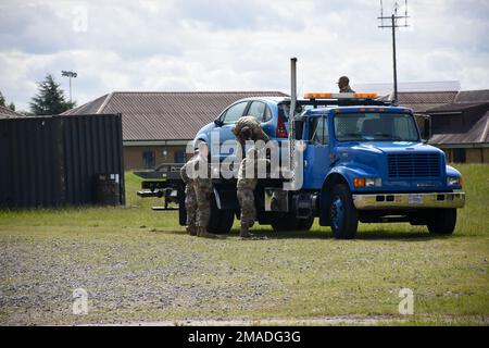 Mitglieder des 442d Logistics Readines Staffelflugs trainierten am 25. Mai 2022 in Royal Air Force Mildenhall, England, ein gestrandetes Auto auf einen Tieflader zu heben und einen simulierten Tankwagen abzuschleppen. Die Schulung wurde von Herrn Nicholas Turpin, dem 100 LRS Vehicle Operations Training Manager, durchgeführt. Stockfoto