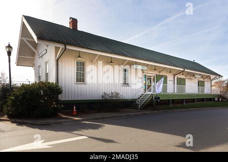 MATTHEWS, NC, USA-15. JANUAR 2023: Historisches Bahnhofsgebäude, in dem die Handelskammer von Matthews und das Besucherzentrum und Museum untergebracht sind. Sonnig, Stockfoto