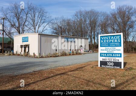 MATTHEWS, NC, USA-15. JANUAR 2023: Antiquitätenladen der Vintage Keepers. Gebäude- und Denkmalschild. Sonniger, blauer Himmel. Stockfoto