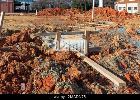 MATTHEWS, NC, USA-15. JANUAR 2023: Nahaufnahme von Schmutz, Bewehrungsstahl, Formen und Betonfußböden auf einer kommerziellen Baustelle. Stockfoto