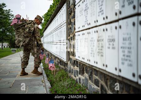 Soldaten aus den 3D USA Infanterie Regiment (die Alte Garde) sowie Mitglieder des US-amerikanischen Militärs Marine Corps, die USA Navy, die USA Air Force und die USA Küstenwache, platzieren Sie am Arlington National Cemetery im Rahmen von Flags-in, Arlington, Virginia, am 26. Mai 2022 US-Flaggen an jedem Grab. An diesem Tag setzten mehr als 1.000 Militärangehörige Flaggen an mehr als 250.000 Grabsteinen und am Ende von etwa 7.000 Nischenreihen auf dem Arlington National Cemetery und den USA Soldiers' and Airmen's Home National Cemetery. Stockfoto