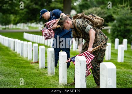 Soldaten aus den 3D USA Infanterie Regiment (die Alte Garde) sowie Mitglieder des US-amerikanischen Militärs Marine Corps, die USA Navy, die USA Air Force und die USA Küstenwache, platzieren Sie am Arlington National Cemetery im Rahmen von Flags-in, Arlington, Virginia, am 26. Mai 2022 US-Flaggen an jedem Grab. An diesem Tag setzten mehr als 1.000 Militärangehörige Flaggen an mehr als 250.000 Grabsteinen und am Ende von etwa 7.000 Nischenreihen auf dem Arlington National Cemetery und den USA Soldiers' and Airmen's Home National Cemetery. Stockfoto