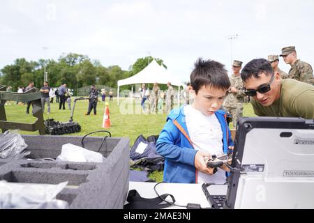 USA Marine Corps Sgt. Radcliff T. Humphrey, ein EOD-Techniker beim 8. Engineer Support Battalion, zeigt einem Studenten der Philip G. Vroom Community School, wie man einen MTRS-Roboter während der Fleet Week New York 2022 im Lincoln Park, New Jersey, am 26. Mai 2022 manövriert. Die Flottenwoche New York findet seit 1984 fast jedes Jahr statt, um die Seeverkehrsdienste des Landes zu feiern und ihre innovativen Fähigkeiten hervorzuheben. Gleichzeitig bietet sie den Bürgern von New York City und der umliegenden Dreistaatenregion die Möglichkeit, Matrosen, Marines und Küstenwachmännern zu begegnen. Stockfoto