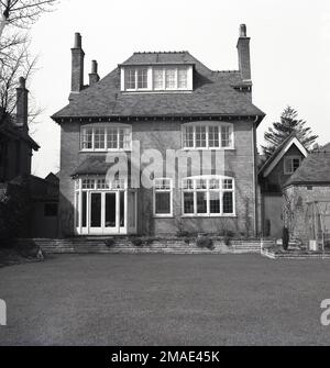 1960er, historisch, Rückansicht, von einem Garten hinten, eines großen, Backsteinbauten, freistehendes, dreistöckiges Vorstadthaus, England, Großbritannien. Stockfoto