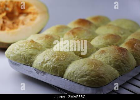 Kürbisbrötchen. Weiche und butterige Brötchen aus Kürbispüree im Backblech frisch aus dem Ofen. Auf weißem Hintergrund mit Witz aufgenommen Stockfoto