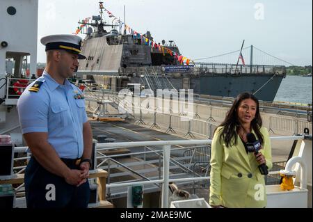 NEW YORK (26. MAI 2022) – USA Küstenwache LT. Blake Bonifas, Executive Officer der USA Coast Guard Cutter Sycamore (WLB-209), Interviews mit Fox News Reporterin Kayla Mamelak am Homeport Pier in Staten Island, New York während der Fleet Week. Die Fleet Week New York, jetzt im 34. Jahr, ist die altehrwürdige Feier der Seeverkehrsdienste der Stadt. Es ist eine einmalige Gelegenheit für die Bürger von New York und der umliegenden Tri-State-Region, Matrosen, Marines und Küstenwachleute zu treffen und die neuesten Fähigkeiten der heutigen Seeverkehrsdienste aus erster Hand zu erleben. Die einwöchige Feier fand statt Stockfoto