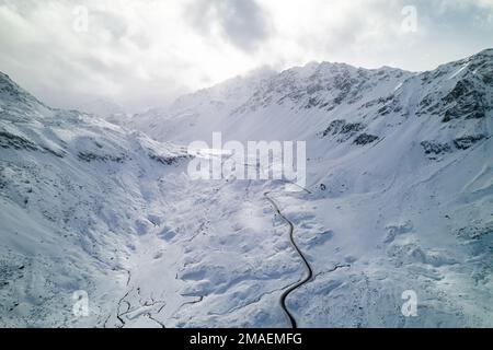 Schneebedeckte Berggipfel im Winter an einem sonnigen Tag mit Wolken im Fluela Pass, Davos, Schweiz. Stockfoto