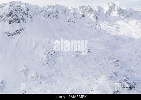 Schneebedeckte Berggipfel im Winter an einem sonnigen Tag mit Wolken im Fluela Pass, Davos, Schweiz. Stockfoto