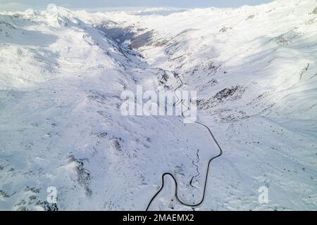 Schneebedeckte Berggipfel im Winter an einem sonnigen Tag mit Wolken im Fluela Pass, Davos, Schweiz. Stockfoto