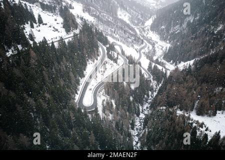 Schneebedeckte Landschaft mit einer Straße durch einen Bergpass in der Schweiz. Stockfoto