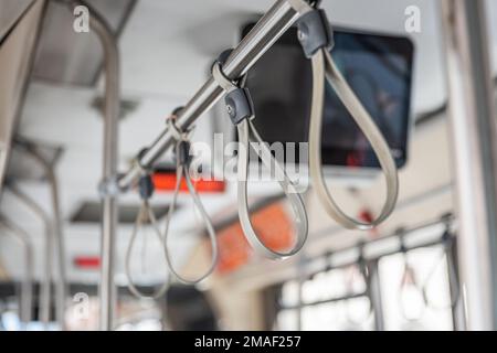 Graue Gurte zum Festhalten an öffentlichen Verkehrsmitteln Busfahrer in Rom, Italien Stockfoto