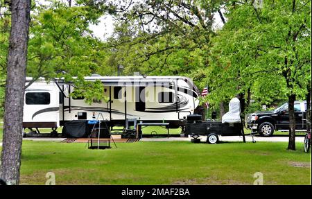 Auf einem Campingplatz am 26. Mai 2022 am Pine View Campground in Fort McCoy, Wisconsin, wird ein Camper aufgestellt. Pine View Campingplatz ist Teil des Pine View Erholungsgebiets. In diesem Gebiet befinden sich auch Whitetail Ridge und Sportsman’s Range. Der Campingplatz liegt in einem bewaldeten Gebiet rund 400 m westlich des Kantonationsgebiets von Fort McCoy und wird im Osten vom Suukjak Sep Lake und im Westen und Süden vom La Crosse River begrenzt. Weitere Informationen zu den Mietpreisen für Kabinen erhalten Sie im Büro des Campingplatzes oder unter https://mccoy.armymwr.com. Stockfoto