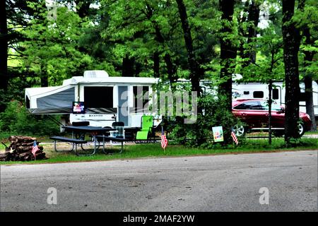 Auf einem Campingplatz am 26. Mai 2022 am Pine View Campground in Fort McCoy, Wisconsin, wird ein Camper aufgestellt. Pine View Campingplatz ist Teil des Pine View Erholungsgebiets. In diesem Gebiet befinden sich auch Whitetail Ridge und Sportsman’s Range. Der Campingplatz liegt in einem bewaldeten Gebiet rund 400 m westlich des Kantonationsgebiets von Fort McCoy und wird im Osten vom Suukjak Sep Lake und im Westen und Süden vom La Crosse River begrenzt. Weitere Informationen zu den Mietpreisen für Kabinen erhalten Sie im Büro des Campingplatzes oder unter https://mccoy.armymwr.com. Stockfoto