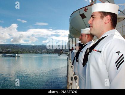 060502-N-3714J-030. [Complete] Scene Caption: US Navy (USN) Seeleute bewachen die Schienen an Bord des USN Military Sealift Command (MSC), Hospital Ship, USNS MERCY (T-AH 19), während das Schiff das USS ARIZONA Memorial auf der Navy Base Pearl Harbor, Hawaii (HI) passiert. Die USNS MERCY beginnt einen geplanten fünfmonatigen Einsatz, um Hilfe und humanitäre Hilfe für die Pazifikinseln und Südostasien zu liefern.Hawaii (Mai 22006) -- Corpsman Shaun Thomasof the WoodlandsTexasmans die Schienen des Navy-Krankenhausschiffs USNS Mercy (T-AH19), während sie das USS Arizona Memorial passieren. Mercy ist auf Hawaii und hat einen geplanten Hafenbesuch Stockfoto