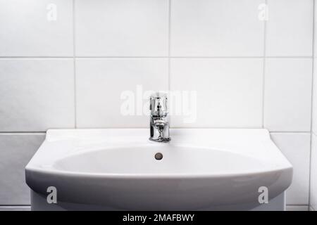 Waschbecken im Badezimmer. WC-Wasserhahn, Wasserhahn und WC-Waschbecken. Innenausstattung der öffentlichen, privaten oder Hoteltoiletten. Leicht und sauber. Händewaschen im Waschraum. Stockfoto