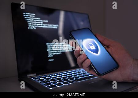 Cyber-Sicherheit auf Smartphones und Laptops zum Schutz vor Betrug, Cyberangriffen oder Identitätsdiebstahl. Elektronischer mobiler Betrug, Computerkriminalität im Internet. Stockfoto