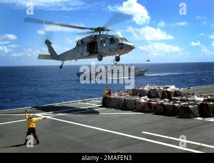 060514-N-3714J-060. [Complete] Bildunterschrift: US Navy (USN) Aviation Boatswain's Mate Handler Second Class (AB2) Brandon Reyes (unten links) Signalisiert dem Piloten eines MH-60 Knighthawk-Hubschraubers vom USN Helicopter Sea Combat Squadron 25 (HSC-25) in Guam während des Vertikalauffüllungsbetriebs (Vertical Replenishment, VERTREP) auf dem Flugdeck des USN Military Sealift Command (MSC) Mercy Class Hospital Ship USNS MERCY (T-AH 19) während ihres fünfmonatigen Einsatzes im Pazifikraum. Die GNADE wird sich an der humanitären Hilfe und an zivilen Aktionsprogrammen mit zivilen Organisationen auf mehreren Inseln beteiligen Stockfoto