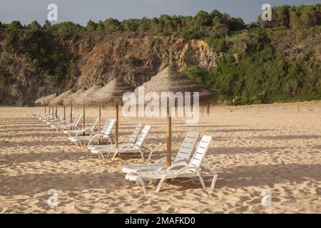 Sonnenliegen am Strand von Odeceixe, an der Algarve und in Portugal Stockfoto