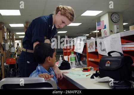 060704-N-3153C-031. [Complete] (Vollständig) Bildunterschrift: US Navy (USN) Lieutenant Junior Grade (LTJG) Keri Krisiak beglückwünscht einen Jungen zu einer Zeichnung, die er machte, während er sich von einer Lippenspaltoperation an Bord des USN Military Sealift Command (MSC) USNS MERCY (T-AH 19) während des Besuchs der humanitären und zivilen Hilfe des Schiffes in Chittagong, Bangladesch (BGD), erholt. Das USN-Schiff ist in Südostasien für fünf Monate im Einsatz. MERCY's Mission wird in enger Abstimmung und Partnerschaft mit lokalen medizinischen Fachkräften und zivilen Freiwilligen des Projekts HOPE (Health Opportunities) durchgeführt Stockfoto