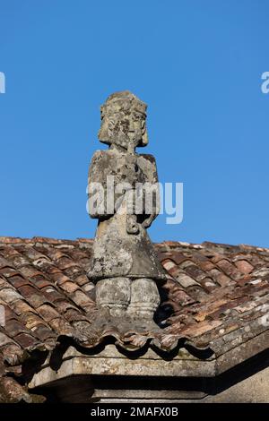 Granitskulptur eines Flötisten auf dem Dach einer Kirche in Galicien, Spanien Stockfoto