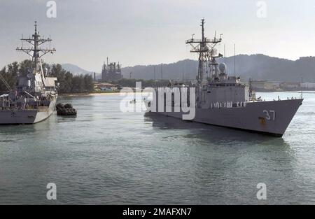 060803-N-9851B-001. [Complete] Szene Caption: 060803-N-9851B-001 (3. August 2006)Steuerbordseite der US Navy (USN) Oliver Hazard Perry Class Guided Missile Frigate USS CROMMELIN (FFG 37) zeigt Seeleute, die die Schienen bemannt, während das Schiff an der USN Arleigh Burke Class (Flug II) Guided Missile Destroyer (Aegis) USS (Aegis) vorbeisegelt (DDG 70) beim Verlassen des Hafens in Kemaman, Malaysia. Die USN-Kriegsschiffe schließen die vierte Phase der Übungskooperation über Wasser ab, um die Bereitschaft und Ausbildung (CARAT) zu gewährleisten. CARAT ist eine jährliche Reihe bilateraler Seefahrtschulungen zwischen den USA und sechs südöstlichen Ländern Stockfoto