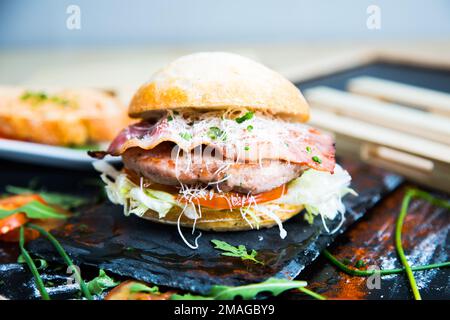 Authentischer, erstklassiger amerikanischer Burger mit Speck, Ei und Salat. Stockfoto