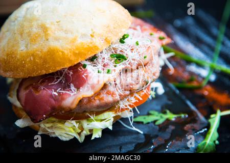 Authentischer, erstklassiger amerikanischer Burger mit Speck, Ei und Salat. Stockfoto