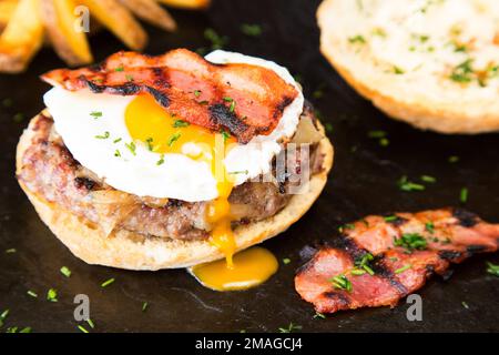 Authentischer, erstklassiger amerikanischer Burger mit Speck, Ei und Salat. Stockfoto