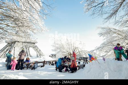 Familien genießen ihre Mittagspause im Freien auf dem Schnee, Mount Amiata, Toskana, Italien Stockfoto