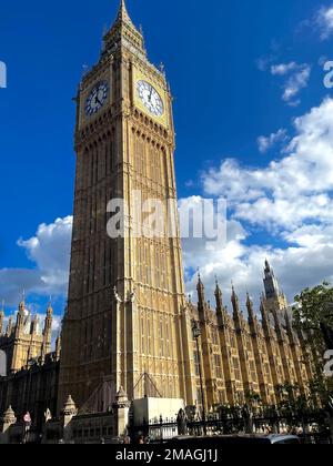 Eine vertikale Skyline von Big Ben vor dem blauen Himmel mit flauschigen Wolken in London an einem sonnigen Tag Stockfoto