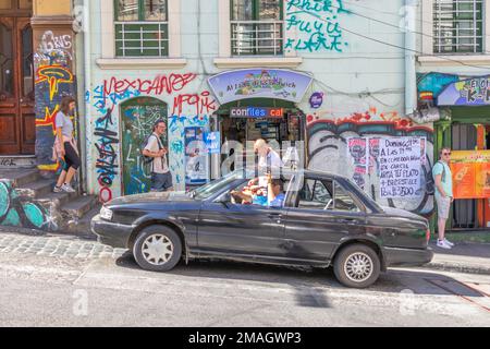 Valparaiso, Chile - 5. Dezember 2022: Farbenfrohe Häuser voller Graffiti in einer steilen Straße von Valparaiso, das von zum Weltkulturerbe erklärt wurde Stockfoto