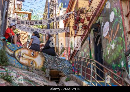 Valparaiso, Chile - 5. Dezember 2022: Farbenfrohe Häuser voller Graffiti in einer steilen Straße von Valparaiso, das von zum Weltkulturerbe erklärt wurde Stockfoto