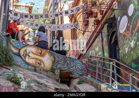 Valparaiso, Chile - 5. Dezember 2022: Farbenfrohe Häuser voller Graffiti in einer steilen Straße von Valparaiso, das von zum Weltkulturerbe erklärt wurde Stockfoto