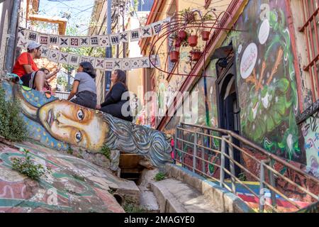 Valparaiso, Chile - 5. Dezember 2022: Farbenfrohe Häuser voller Graffiti in einer steilen Straße von Valparaiso, das von zum Weltkulturerbe erklärt wurde Stockfoto