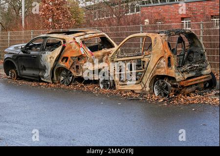 Berlin, Deutschland - 12. Dezember 2022: Wracks von zwei ausgebrannten Autos am Straßenrand. Stockfoto
