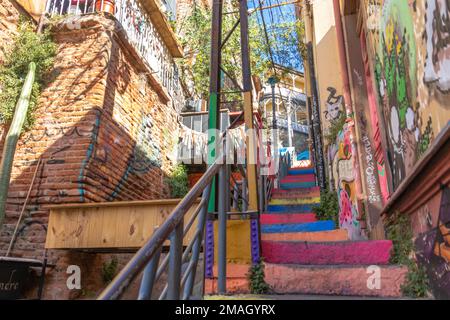 Valparaiso, Chile - 5. Dezember 2022: Farbenfrohe Treppen und Häuser voller Graffiti auf einer steilen Straße von Valparaiso, das zum Weltkulturerbe erklärt wurde Stockfoto