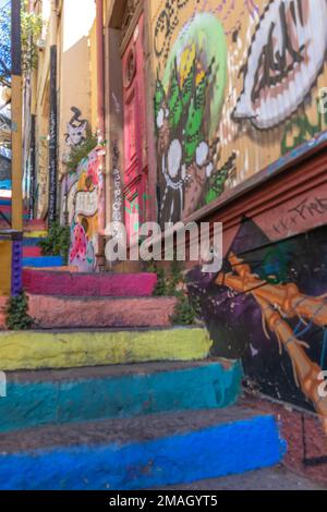 Valparaiso, Chile - 5. Dezember 2022: Farbenfrohe Treppen und Häuser voller Graffiti auf einer steilen Straße von Valparaiso, das zum Weltkulturerbe erklärt wurde Stockfoto