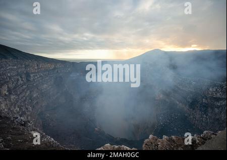 Tiefes Kraterloch im Erdland mit Rauch steigt. Dampf vom Vulkan des Masaya-Kraters Stockfoto