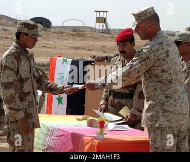 070308-M-5865P-114. [Complete] Bildunterschrift: 8. März 2007, STAFF SGT. Aslan Altan, STABSOFFIZIER, zuständig für das Militär-Übergangsteam 2D, Brigade 7., Abteilung der irakischen Armee (Mitt 2-7), schüttelt einem irakischen Soldaten die Hand, während er ihm sein Zertifikat während des ersten Graduiertenabschlusses irakischer Soldaten von der Schule der Infanterie (SOI) in Camp Yasser überreicht; Luftwaffenstützpunkt Al Asad, Irak. SOI ist eine zehntägige Ausbildungsschule, die neuen irakischen Soldaten Kampftechniken und Taktiken beibringt, bevor sie sich in ihren Bataillonen melden. Mitt 2-7 wird als Teil von MNF-W zur Unterstützung von o eingesetzt Stockfoto