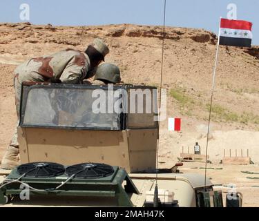 070319-M-7404B-009. [Complete] Szene Caption: Ein Ausbilder mit dem 2. Brigade 7. Iraqi Army Division Military Transition Team (Mitt 2-7) Unterrichtet einen irakischen Armeesoldaten, während er am 9. März 2007 auf dem Luftwaffenstützpunkt Asad, Irak, eine PKC-Maschinenpistole aus dem Geschützturm eines hochbeweglichen Mehrradfahrzeugs (HMMWV) abfeuert. 2. Bataillon 7. Das militärische Übergangsteam der irakischen Armee-Division wird als Teil der MNF-W zur Unterstützung der Operation Iraqi Freedom in der Provinz Anbar im Irak eingesetzt, um die irakischen Sicherheitskräfte zu entwickeln und die Entwicklung zu erleichtern Stockfoto