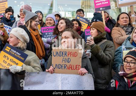 Krankenschwestern außerhalb des UCH Hospital, London, streiken nach mehr Bezahlung und verbesserter Personalausstattung mit Plakaten „unterbezahlt, unterbewertet“. Stockfoto