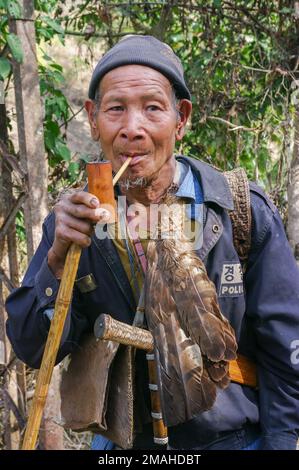 Raga, Arunachal Pradesh, Indien - 02 20 2013 : Außenportrait mit Halbkörperfront des alten Nyishi-Stammes, der traditionelle Bambuspfeife raucht Stockfoto