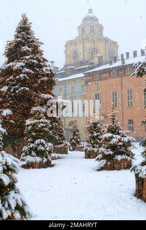 Weihnachtsbäume mit Schnee vor der Kirchenkuppel San Lorenzo im Stadtzentrum von Turin. Piazza Castello, Turin, Italien. Stockfoto